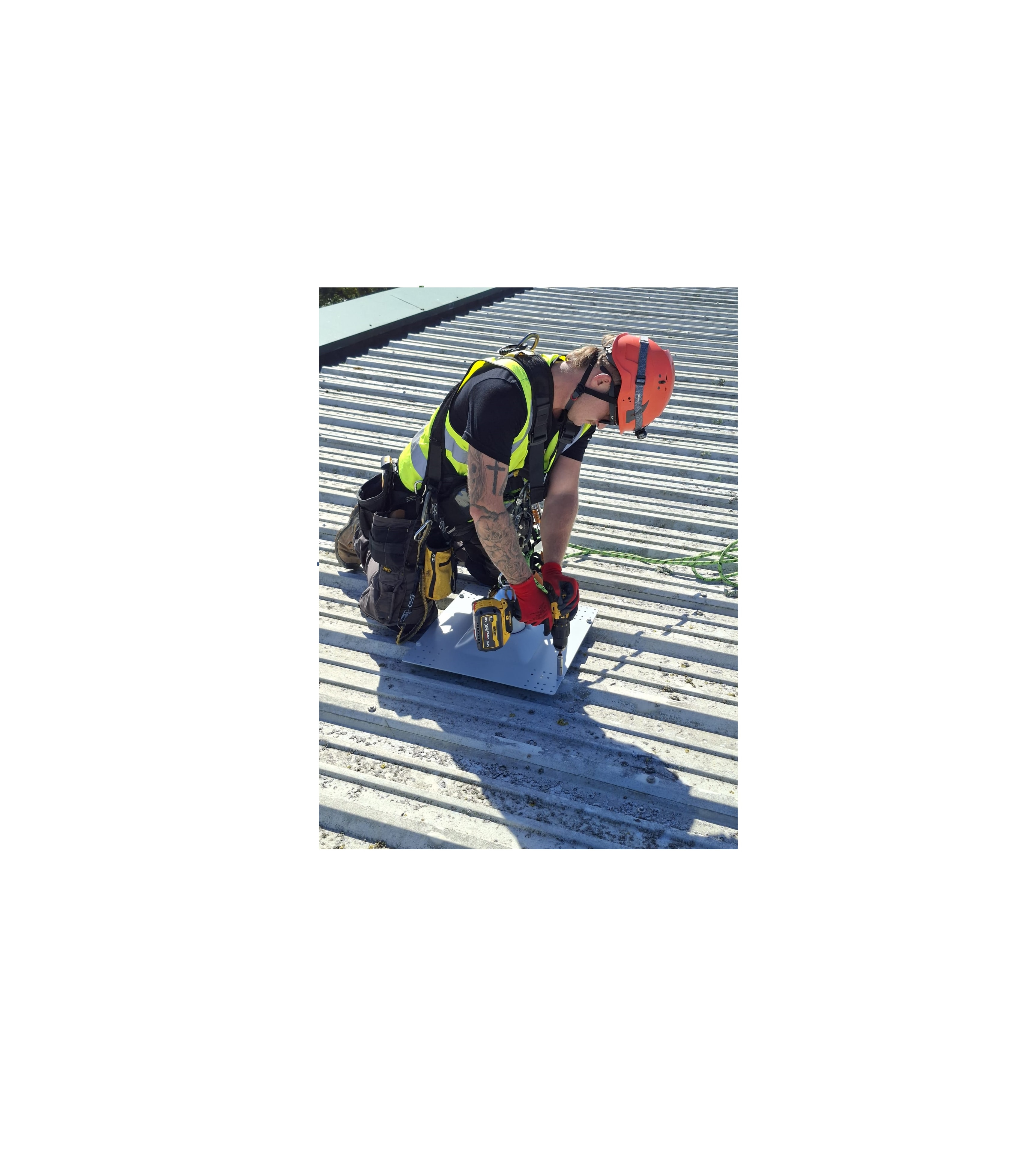 SAS Safety Group operative drilling an anchor base plate on a corrugated metal roof